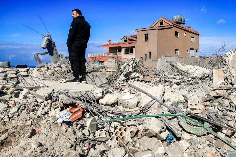 A man stands amidst the rubble of destroyed buildings following strikes on the the town of Naqura in southern Lebanon close to the border with northern Israel on January 4, 2024.