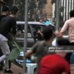 A bodyguard of former Lebanese Member of Parliament Mosbah Ahdab uses an assault rifle to fire shots in the air from his car while surrounded by demonstrators amidst ongoing protests against dire economic conditions in the northern coastal city of Tripoli on October 18, 2019. - Public anger has simmered since parliament passed an austerity budget in July to help trim a ballooning deficit and flared on October 17 over new plans to tax calls on messaging applications such as WhatsApp, forcing the government to axe the unpopular proposal. (Photo by Ibrahim CHALHOUB / AFP) (Photo by IBRAHIM CHALHOUB/AFP via Getty Images)