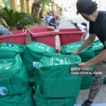 Activists distribute humanitarian aid sent from Saudi Arabia to displaced people from southern Lebanon living in shelters in Tripoli on October 19, 2024. (Photo by Fathi AL-MASRI / AFP) (Photo by FATHI AL-MASRI/AFP via Getty Images)