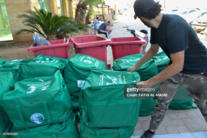 Activists distribute humanitarian aid sent from Saudi Arabia to displaced people from southern Lebanon living in shelters in Tripoli on October 19, 2024. (Photo by Fathi AL-MASRI / AFP) (Photo by FATHI AL-MASRI/AFP via Getty Images)